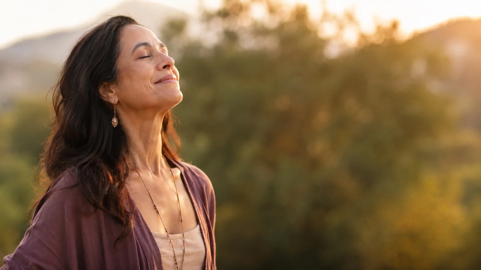 Femme apaisée respirant au coucher du soleil